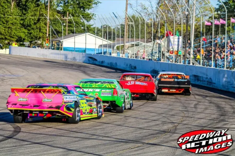 Stock cars heading into turn one in front of the grandstands