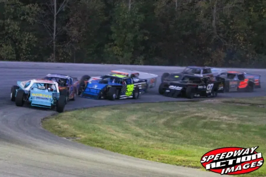 Modifieds racing through the turn at dusk