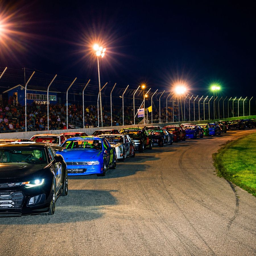 Cars lined up under the lights at night